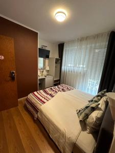 a bedroom with a large bed and a window at Yasha Hotel in Luxembourg