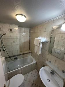 ein Badezimmer mit einer Badewanne, einem WC und einem Waschbecken in der Unterkunft Yasha Hotel in Luxemburg (Stadt)