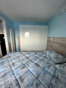 ein Schlafzimmer mit einem großen Bett und einem weißen Schrank in der Unterkunft BELLAVISTA APARTMENT in Passo del Tonale