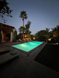 ein Pool im Hinterhof in der Nacht in der Unterkunft Villa avec piscine et golf in Marrakesch