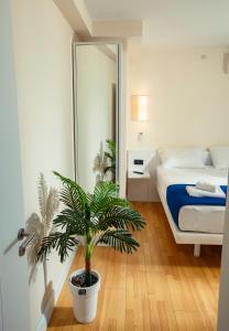 - une chambre avec un lit et une plante en pot dans l'établissement Panorama Orbi Resort, à Batoumi