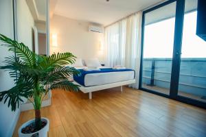 1 dormitorio con 1 cama y una maceta en Panorama Orbi Resort en Batumi