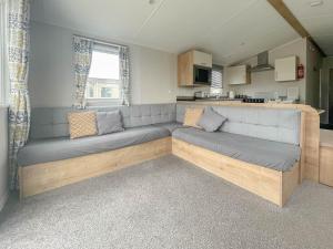 a living room with a large couch in a caravan at Wonderful 8 Berth Caravan With Decking At Valley Farm, Essex Ref 46561v in Great Clacton