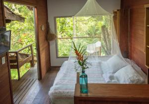 Cette chambre comprend un lit avec un vase sur une table. dans l'établissement Casa Grande Flats, à Abraão