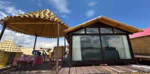 a gazebo with an umbrella on a deck at TITICACA WORLDWIDE LODGE in Puno