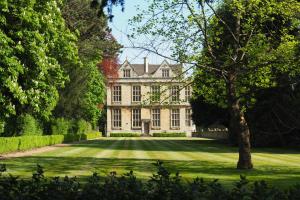 a large white house with a tree in the yard at The Hall Estate - Historic Grade I-listed Jacobean Mansion in Bradford on Avon