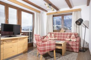 ein Wohnzimmer mit einem Sofa und einem TV in der Unterkunft Alpenherz Ferienwohnungen in Pertisau