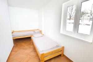 two beds in a room with a window at Jestřebí chalupa in Rtyně v Podkrkonoší