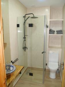 a bathroom with a shower and a toilet at Dar Makai Surf Hotel in Tamraght Ouzdar