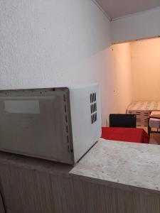 um micro-ondas sentado num balcão num quarto em Casa compacta em São Caetano do Sul