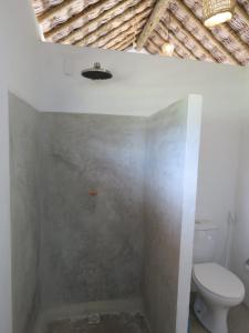 a bathroom with a toilet and a bath tub at Pitico Chalé - Icaraí Kite Village in Icaraí