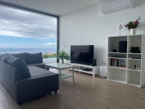 salon z kanapą i telewizorem w obiekcie Villa Sea View w mieście Arco da Calheta