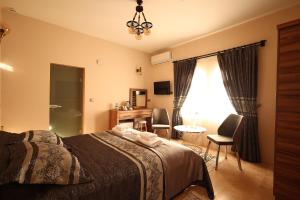 1 dormitorio con 1 cama, escritorio y sillas en Hotel İzi Cappadocia, en Ürgüp