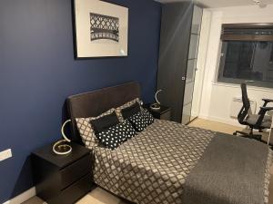 a bedroom with a bed and a blue wall at Charming 2-Bed Apartment in Bow London in London
