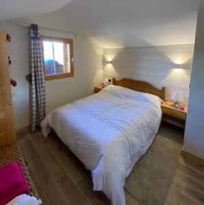 a bedroom with a large white bed with a window at Signal 308 apartment 6 person in Aime-La Plagne
