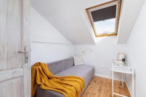 Cette petite chambre comprend un canapé et une fenêtre. dans l'établissement Starowiślna Apartment with AC & Pet-Friendly by Renters, à Cracovie
