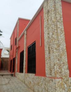 a red building with a stone wall at La Villa Maria in Dakar