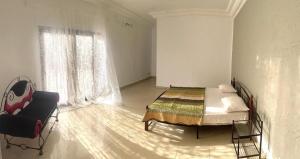 a bedroom with a bed and a chair and a window at La Villa Maria in Dakar