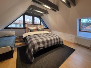 a attic bedroom with a bed and a couch at LIPNO BEACH SIDE - RIVIERA APARTMENT in Lipno nad Vltavou
