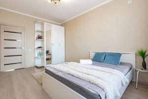 1 dormitorio con 1 cama grande con almohadas azules en Хан Шатыр, en Taldykolʼ