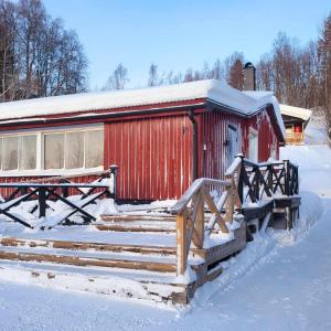 a red barn with snow on top of it at Kultsjögården-Saxnäs- Marsfjäll 10 in Saxnäs