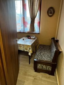 een kamer met een tafel, een stoel en een raam bij Апартамент Миели in Sofia