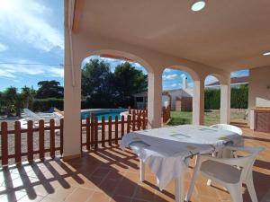 a patio with a table and chairs and a pool at VILLA REPOSO in Calafat