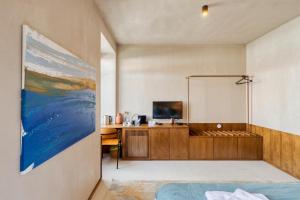 een slaapkamer met een bed en een bureau met een televisie bij Azul by the Sea in Setúbal