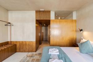 een slaapkamer met een bed en een houten muur bij Azul by the Sea in Setúbal