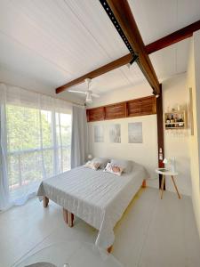 1 dormitorio con cama y ventana grande en Contêiner 10 Hospedagem en Serra
