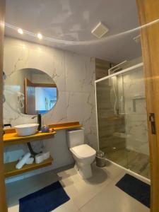 a bathroom with a toilet and a sink and a shower at Pousada Águas da Grota in Penha
