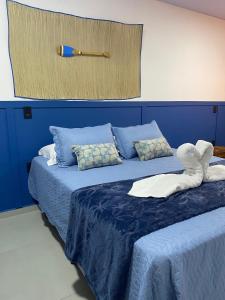 a bedroom with two beds with blue sheets at Pousada Águas da Grota in Penha