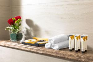 a shelf with towels and a vase of flowers at ايليت الخالدية in Al Madinah