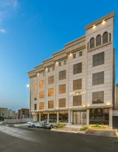 un gran edificio con coches estacionados en un estacionamiento en ايليت الخالدية, en Medina