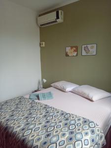 um quarto com uma cama e ar condicionado na parede em Apartamento 5 min do Consulado Americano Porto Alegre em Porto Alegre