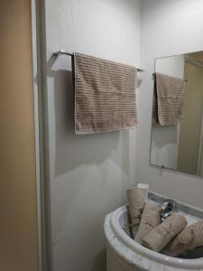 a bathroom with a sink and a mirror and towels at Emplacement idéal, garage privé, piscine intérieure in Uzès