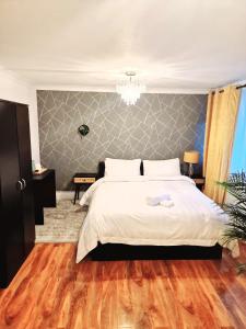 sypialnia z dużym białym łóżkiem i drewnianą podłogą w obiekcie Flat 16 Homedale house w mieście Sutton