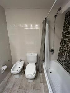 a bathroom with a toilet and a tub and a sink at DADELF in Rosario +12 photos