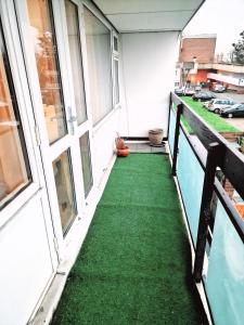 un balcone con pavimenti verdi in un edificio di Flat 16 Homedale house a Sutton