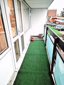 a balcony with green flooring on a building at Flat 16 Homedale house in Sutton