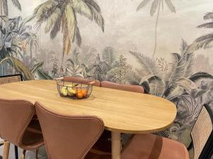 mesa de comedor con sillas y papel pintado tropical en Serenity - 20 mins from Paris en Chelles