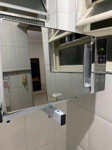 cocina con espejo y microondas en Apartamento Guarujá 5min a pé da Praia da Enseada, en Guarujá