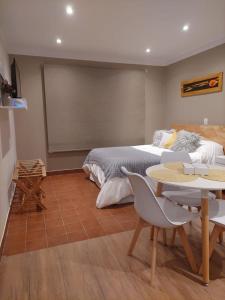 um quarto com uma cama, uma mesa e cadeiras em Departamento completo en San Carlos de Bariloche, Argentina em San Carlos de Bariloche