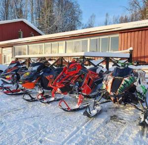 una pila de esquís estacionados en la nieve frente a un edificio en Kultsjögården-Saxnäs- Marsfjäll 10, en Saxnäs