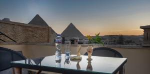 uma mesa com dois copos de vinho e garrafas em King Pyramids View Hotel no Cairo