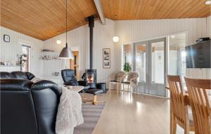 VestervigにあるBeautiful Home In Vestervig With Sauna, Wifi And Indoor Swimming Poolのリビングルーム(黒い革張りのソファ、椅子付)
