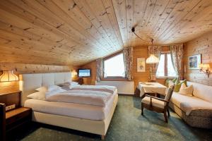 ein Schlafzimmer mit einem großen Bett und einem Sofa in der Unterkunft Chalet Rüfikopf in Lech am Arlberg