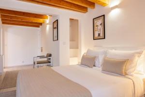 a bedroom with a large white bed with white pillows at Azinheira Suites Townhouse - Alojamento Turístico in Elvas