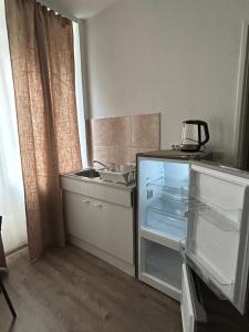 a kitchen with an empty refrigerator and a sink at SkyApartment#101 in Frankfurt