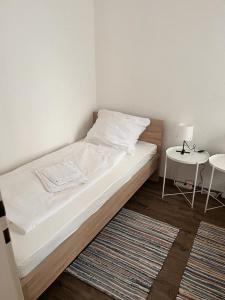 1 dormitorio con 1 cama y 1 mesa con lámpara en SkyApartment#101, en Frankfurt